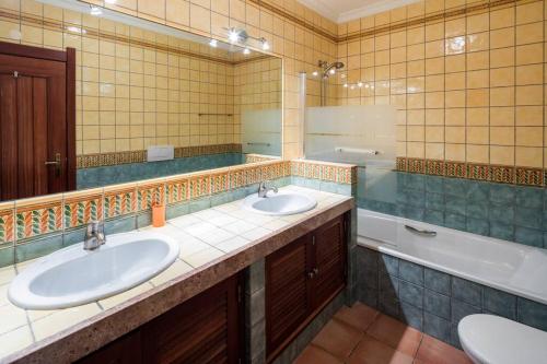 bagno con 2 lavandini, vasca e specchio di Casa Bonita (Terraços de Benagil 37) a Lagoa
