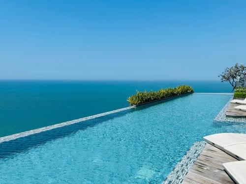 a swimming pool with the ocean in the background at Cosy seaview two bedrooms Nakula in North Pattaya