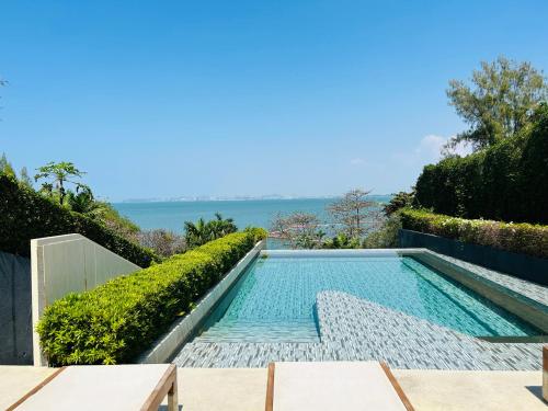 a swimming pool with a view of the ocean at Cosy seaview two bedrooms Nakula in North Pattaya