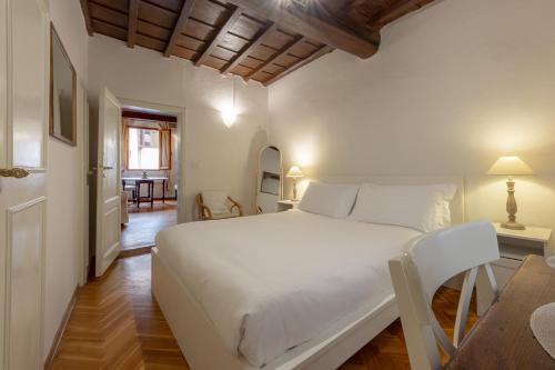 - une chambre avec un grand lit blanc et une salle à manger dans l'établissement Signoria Florentine Apartment, à Florence