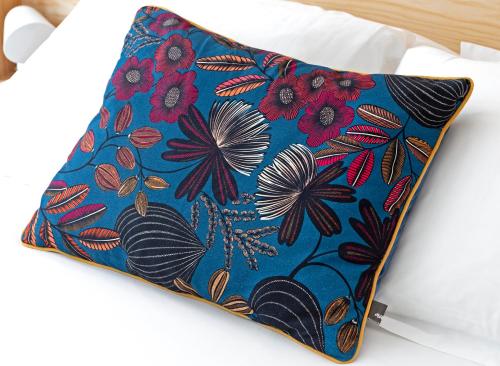 a pillow with a floral pattern on a bed at Happy guesthouse - Grand Place in Brussels