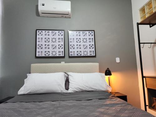 1 dormitorio con 1 cama con 2 cuadros en la pared en Apartamento em Copacabana Posto 6 RJ Studio 7 Copas, en Río de Janeiro