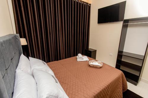 a hotel room with a bed and a television at Sonqu Tarapoto in Tarapoto