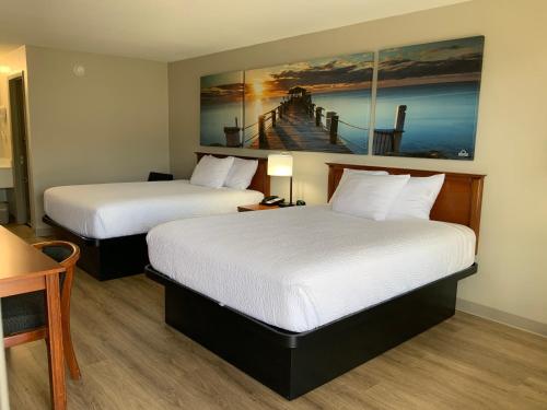 a hotel room with two beds and a painting on the wall at Days Inn by Wyndham Lake City I-10 in Lake City