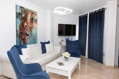 a living room with a white couch and blue chairs at Acapulco playa Nerja 407 planta superior in Nerja