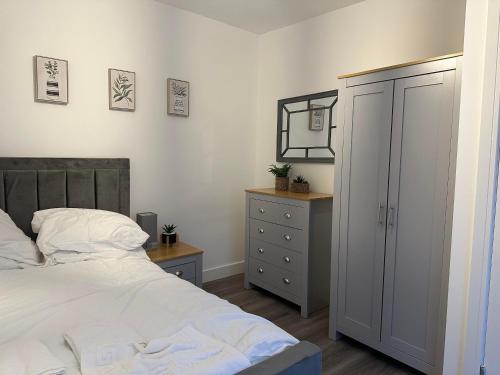 a bedroom with a bed and a dresser and a mirror at Flat in Luton Town Centre in Luton