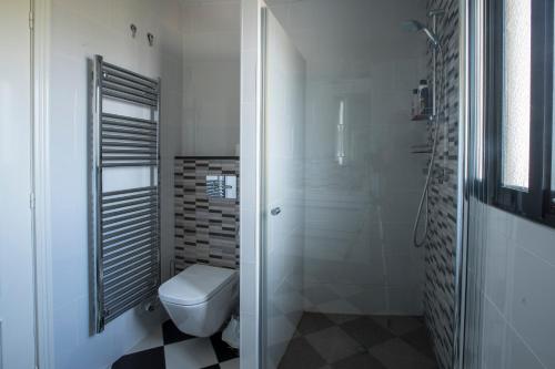 a white bathroom with a toilet and a shower at Finca Tierra Roja in Cálig