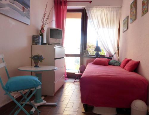 a bedroom with a bed and a table and a tv at NOUVEAU ! Chambre d'Hôte Insolite PRIVEE " CŒURS DE PIRATES à BALI EN PROVENCE" SPA SAUNA MASSAGES dans cadre EXOTIQUE d'Aménagements EXTÉRIEURS D'EXCEPTION ÉTÉ comme HIVER BIENVENUE !!! in Cavalaire-sur-Mer