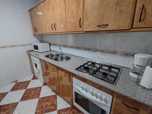 uma cozinha com um lavatório e um fogão forno superior em Casa Fregenal Centro R&S em Fregenal de la Sierra