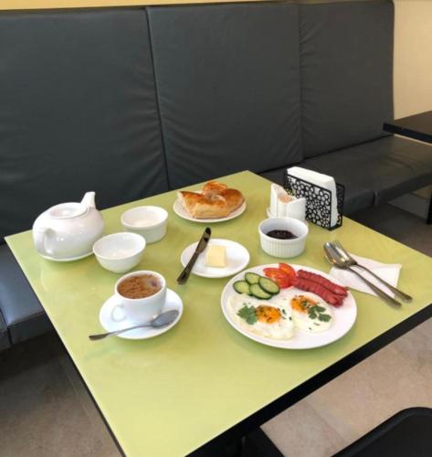 een tafel met borden eten en een kopje koffie bij HOTEL ALMAZ PLAZA in Yakkasaray