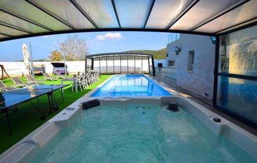 a large swimming pool with a view of a house at וילה אל סלבדור - וילה מדהימה עם בריכה פרטית וג'קוזי in Peqi‘in H̱adasha