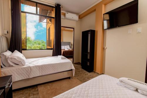 a bedroom with two beds and a large window at Sonqu Tarapoto in Tarapoto
