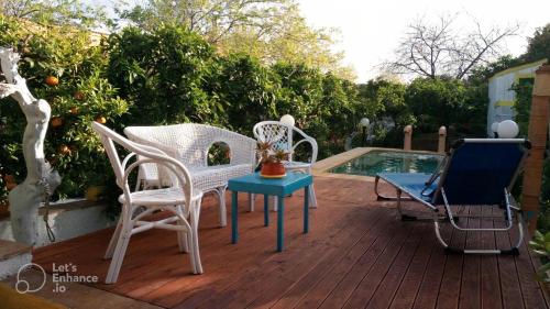 una terrazza con sedie e un tavolo accanto alla piscina di Zagara di Sicilia a Marsala