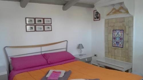 a bedroom with a large bed with purple sheets at Zagara di Sicilia in Marsala
