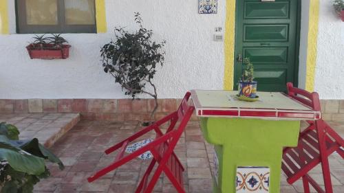 a table in front of a house with a green door at Zagara di Sicilia in Marsala