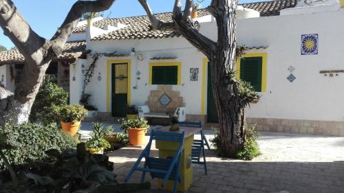 a white house with yellow doors and a tree at Zagara di Sicilia in Marsala