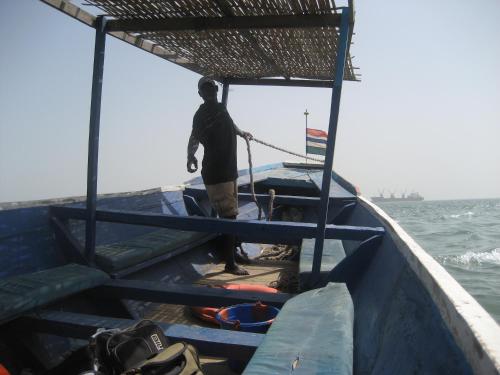 a man standing on a boat in the water at Jinack Lodge in Jinack Island