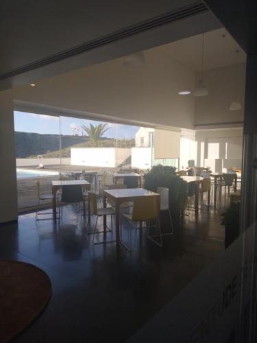 a restaurant with tables and chairs and a large window at Azores Youth Hostels - Santa Maria in Vila do Porto