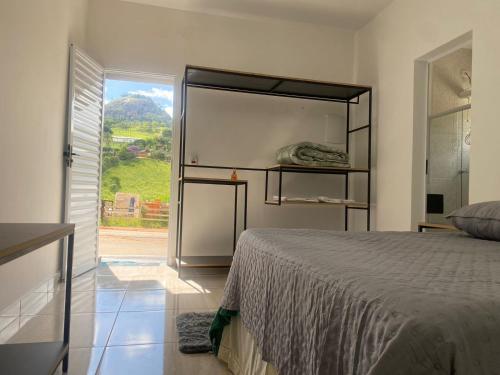 a bedroom with a bed and a large window at VILLAGE Host Hotel in Pedra Bela