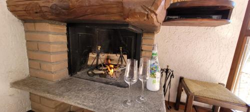 バルツィオにあるMountain lodging with fireplace and mountain viewの暖炉(前にワイングラスとテーブル付)