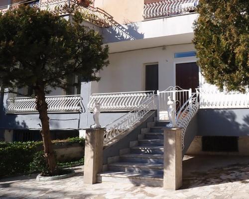 a white staircase leading to a building with a tree at Rachel's guest apartments in Santa Maria Capua Vetere