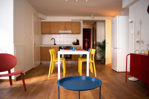 een keuken met een tafel en enkele gele stoelen bij RYB Colour Apartment in Patra