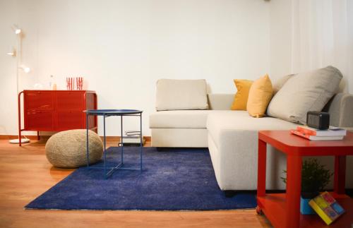 a living room with a white couch and a blue rug at RYB Colour Apartment in Patra