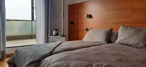 - une chambre avec un grand lit et une grande fenêtre dans l'établissement Apartamento Nevada Sur, à Sierra Nevada