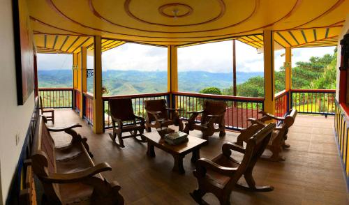 a room with chairs and a table on a balcony at Hotel Terra Belén in Belén de Umbría