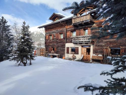 una baita di tronchi con neve di fronte di Silva: The Alpine Chalet a Livigno