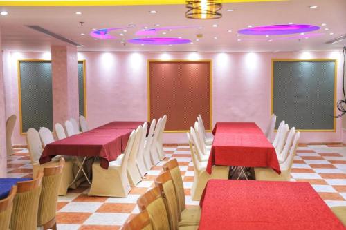 une salle à manger avec des tables rouges et des chaises blanches dans l'établissement Manart Al Misk Hotel, à La Mecque
