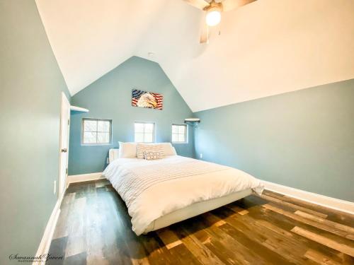 een slaapkamer met een bed met blauwe muren en houten vloeren bij Treesort in Clarks Hill