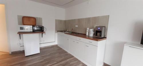 a kitchen with white cabinets and a microwave at Familie Fritz in Gager