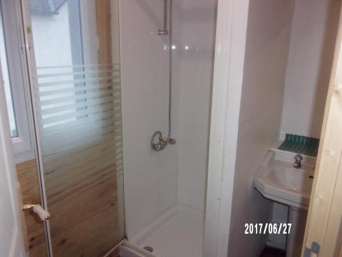 une douche avec une porte en verre à côté d'un lavabo dans l'établissement Logement proche de tout, à Saint-Laurent-de-Neste