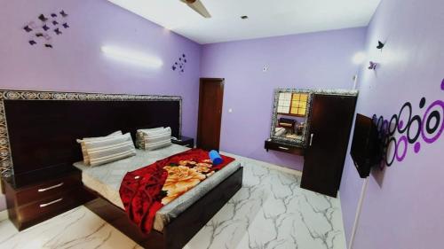 - une chambre avec un lit dans une chambre violette dans l'établissement Best Couple Coprtive Guest House, à Karachi