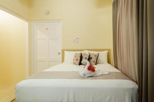 a white stuffed animal sitting on a bed at Cozi Cottage, A Tranquil Beauty in The Rock