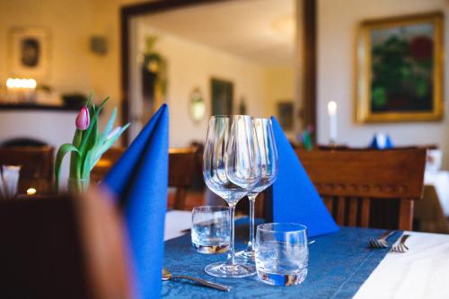 ein Tisch mit blauen Servietten und Weingläsern darauf in der Unterkunft Munkedals Herrgård in Munkedal