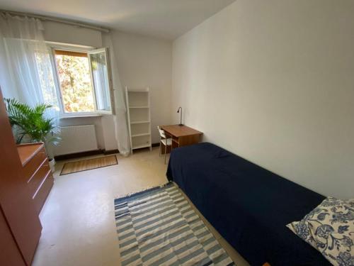 a bedroom with a bed and a desk and a window at Udine Urban Stay in Udine