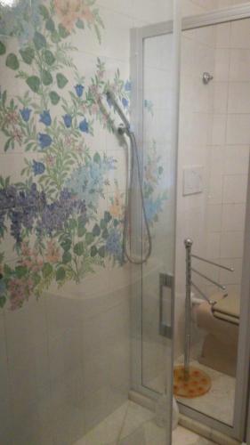 a shower in a bathroom with a floral wallpaper at Villa Daria in Forte dei Marmi