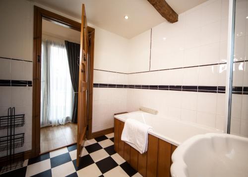 a bathroom with a tub and a sink at The Old Stables at Humblebee Hall in Worcester