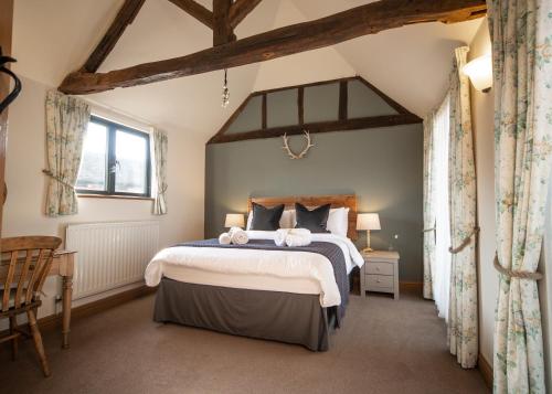 a bedroom with a large bed in a room at The Old Stables at Humblebee Hall in Worcester