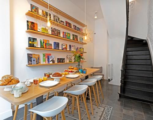 un comedor con una mesa larga y taburetes en Happy guesthouse, en Bruselas