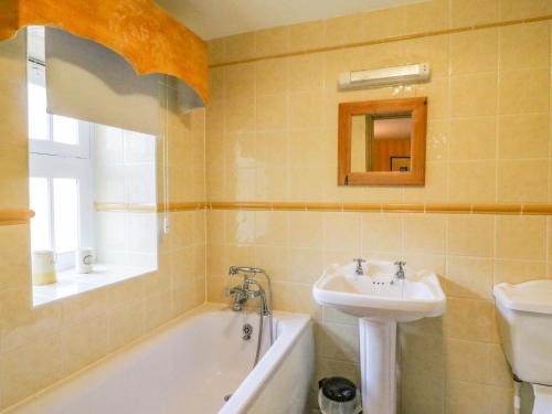 een badkamer met een wastafel, een bad en een toilet bij The Oast House in Weymouth
