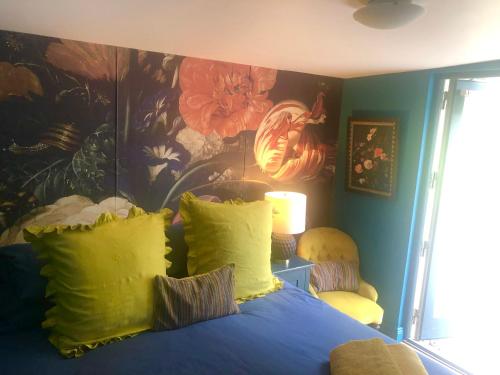 a bedroom with a blue bed with a painting on the wall at The Welcome Snug in Kinsale