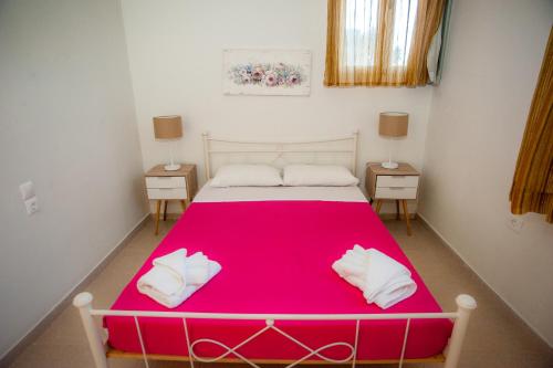 a bedroom with a pink bed with two night stands at Musses Studios in Minia