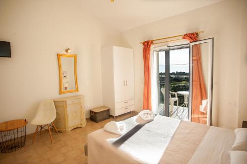 a bedroom with a white bed and a balcony at Musses Studios in Minia