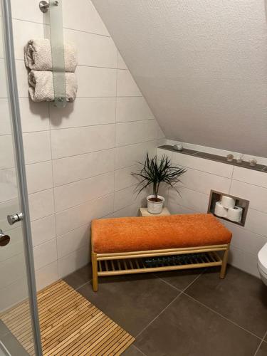 a bathroom with a bench with a plant in it at Haus-Sonneck in Esens