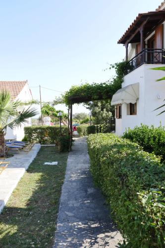 a walkway next to a white building at Jasmine apartments in Pythagoreio