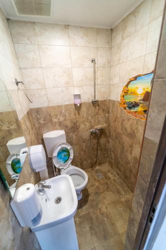 a bathroom with two toilets and a sink and a shower at Philadelphia in Dubova