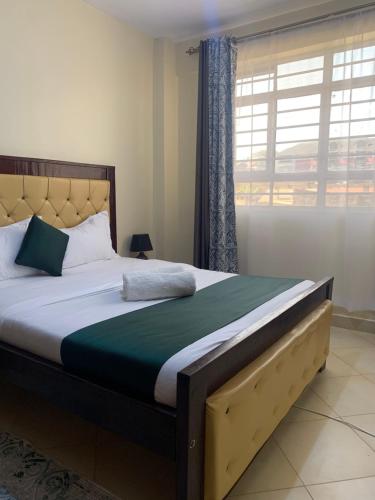 a bedroom with a large bed with a window at Vee's Homestay, Nakuru Town in Nakuru